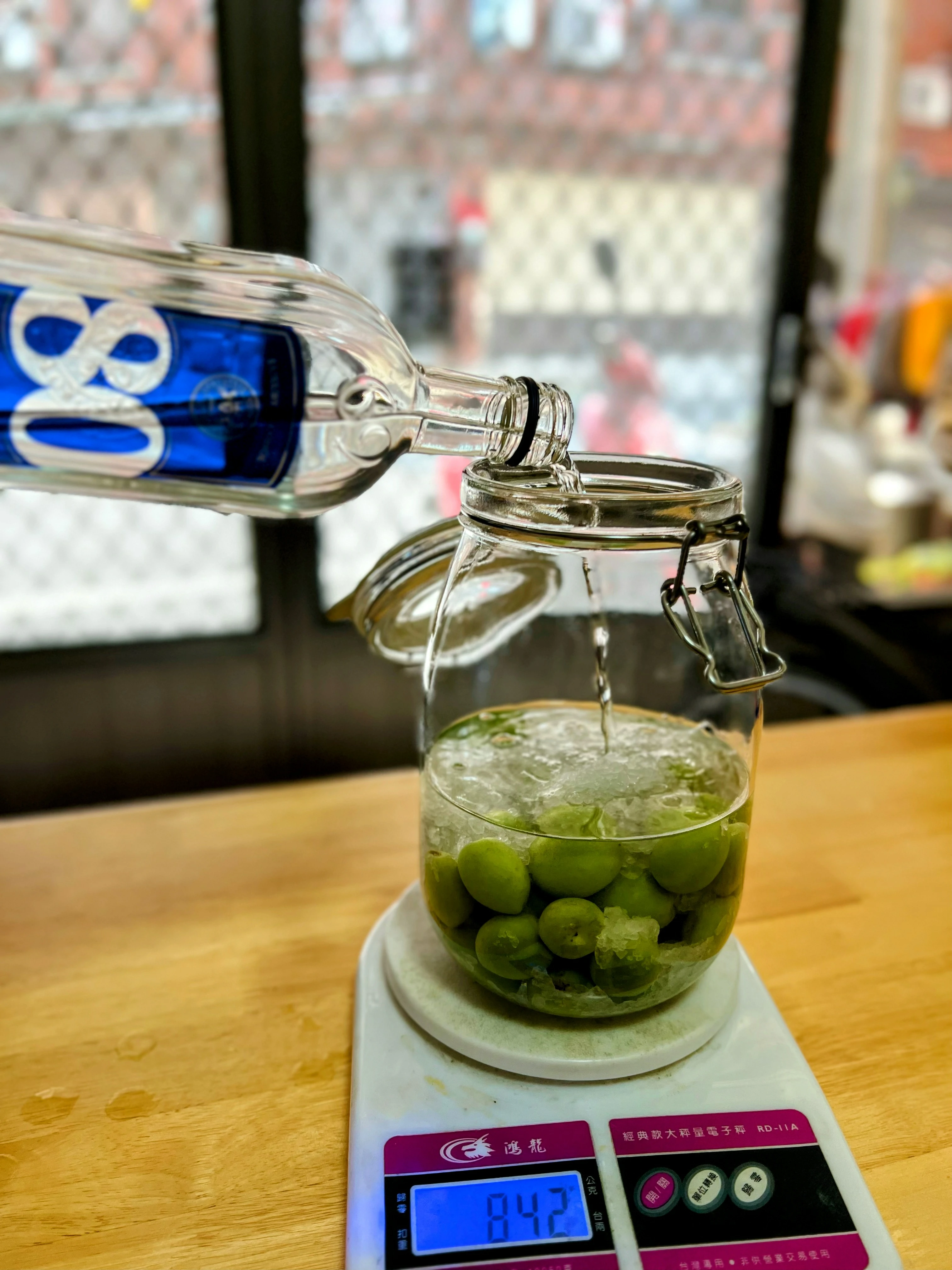 將梅子與冰糖先行放置於容器之中，然後把將基酒緩緩注入